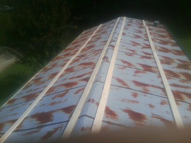 Rusted metal roof panels with new wood purlins before replacement — Storm Damage Roof Repair in Riva by Roofing Brothers