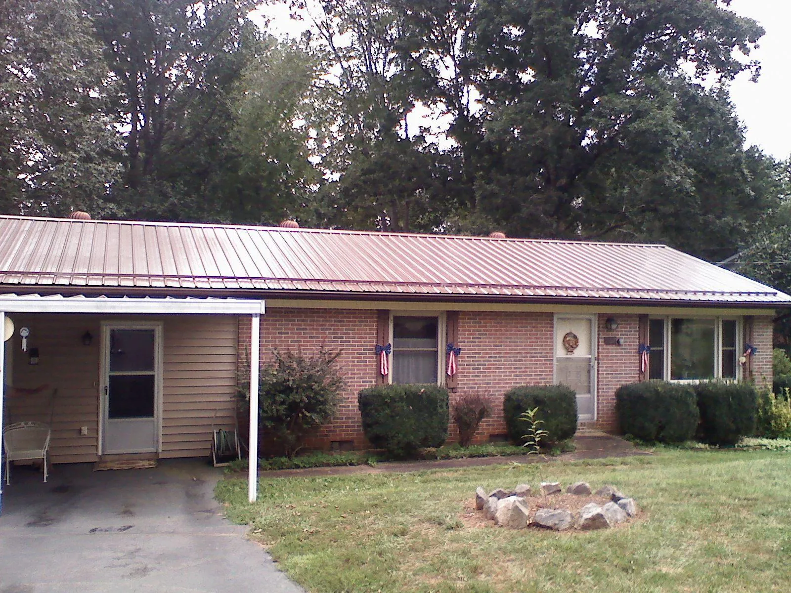 Bronze metal roof and carport on a brick ranch home — Roof Repair work by our crew in Riva